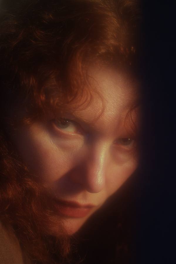 Une femme rousse à demi cachée par le bord du cadre