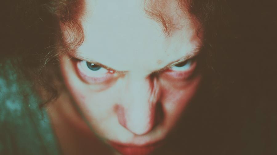 Un visage vu d'en dessous, regard dur, lumière cyan