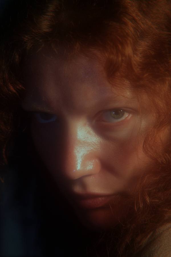 Une femme rousse en gros plan, lumière froide