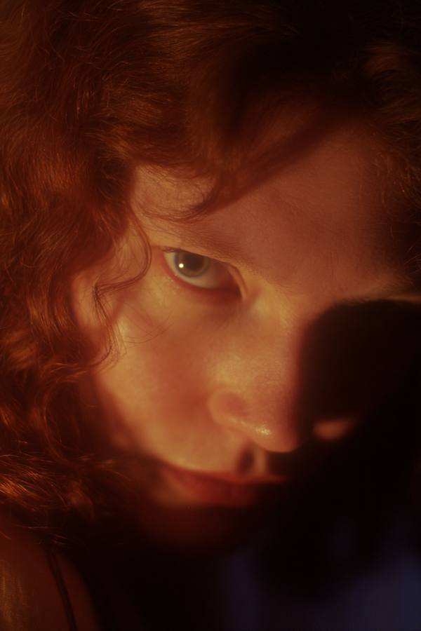 Une femme rousse, la moitié du visage dans l'ombre