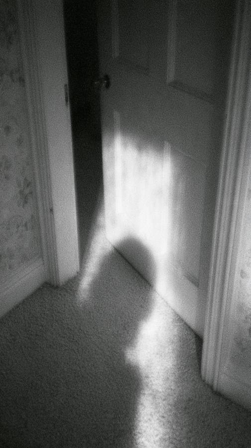 Une porte entrouverte, une ombre sur le sol