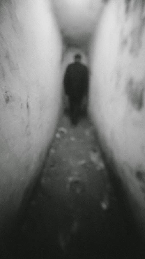 Un couloir étroit, un homme de dos au fond