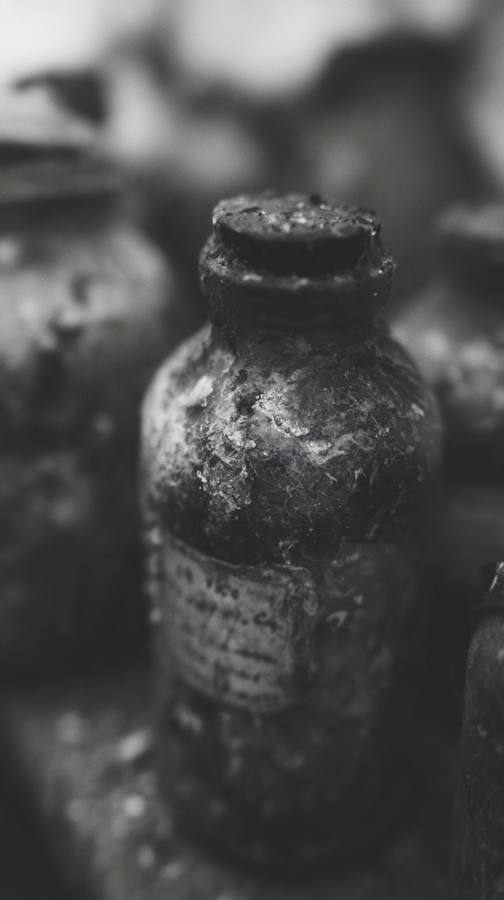 Une bouteille ancienne couverte de poussière, étiquette illisible