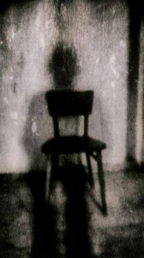 Une chaise et son ombre sur un mur