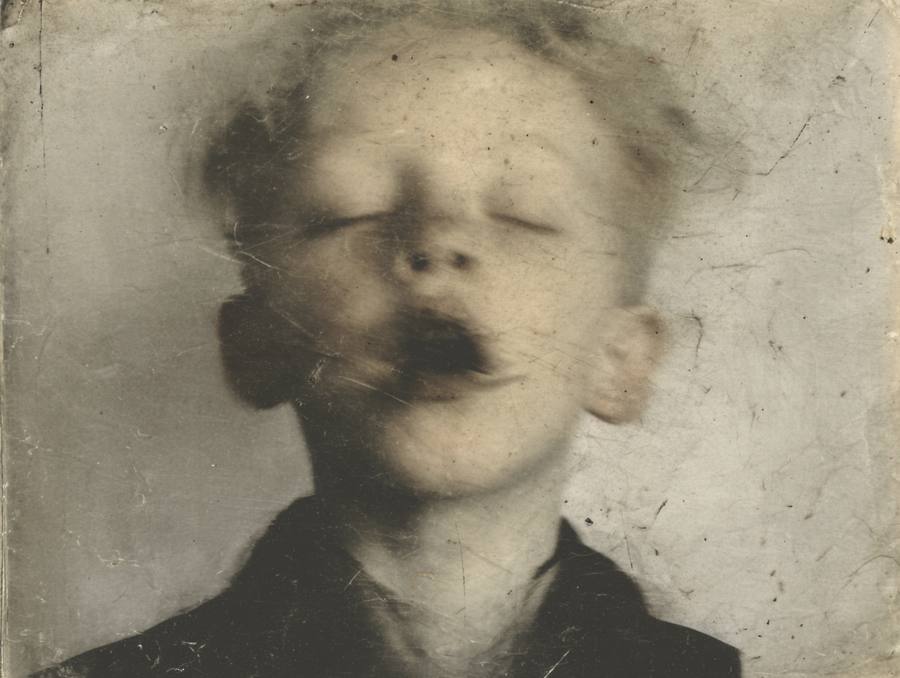 Un garçon aux yeux fermés, de la fumée devant le visage