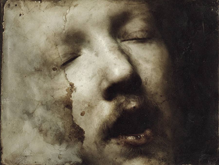 Un visage sépia abîmé, la bouche entrouverte
